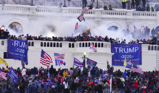 Rioters at the U.S. Capitol on January 6, 2021, in Washington. A former Virginia police officer who stormed the U.S. Capitol has received a reduced prison sentence of six years. Former Rocky Mount Police Sgt. Thomas Robertson's re-sentencing on Wednesday makes him one of the first beneficiaries of a recent U.S. Supreme Court ruling that limited the government’s use of a federal obstruction law.