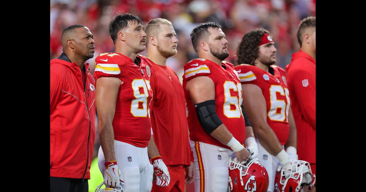 Travis Kelce #87, Mike Caliendo #66 and teammates stand before the Kansas City Chiefs take on the Baltimore Ravens at GEHA Field at Arrowhead Stadium on September 5, 2024 in Kansas City, Missouri.