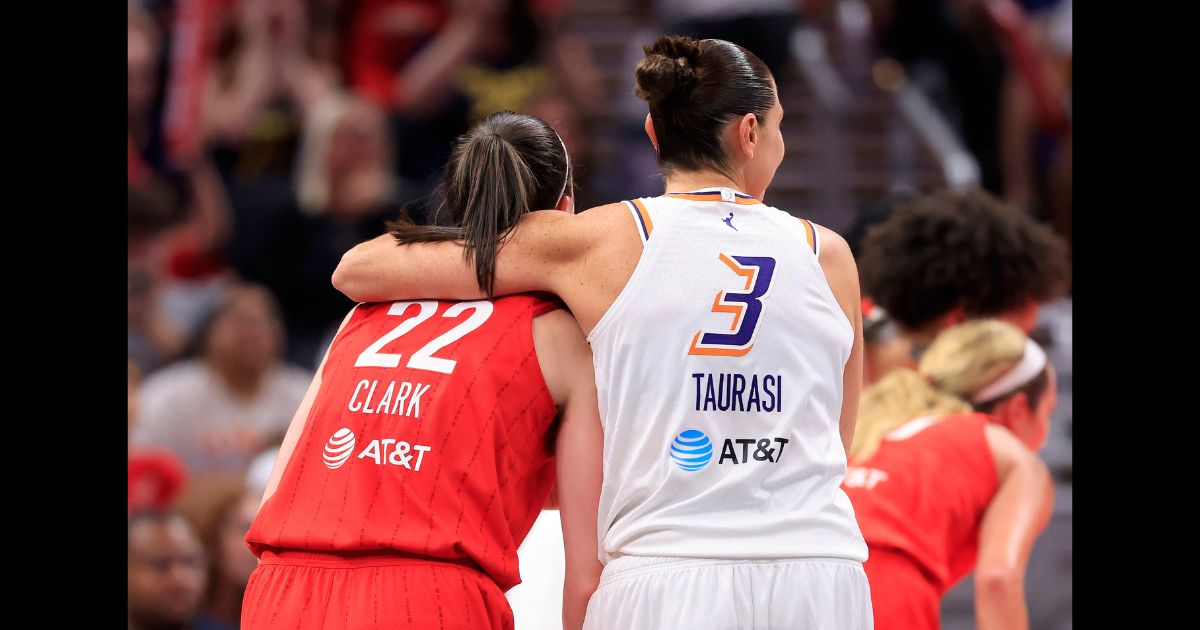 Caitlin Clark #22 of the Indiana Fever and Diana Taurasi #3 of the Phoenix Mercury embrace during the second half at Gainbridge Fieldhouse on August 16, 2024 in Indianapolis, Indiana.