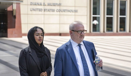 Ladan Mohamed Ali, left, a Seattle woman who attempted to bribe a Minnesota juror with a bag of $120,000 in cash in exchange for an acquittal in one of the country's largest COVID-19-related fraud cases, and her attorney, Eric Newmark, leave the Diana E. Murphy U.S. Courthouse on Thursday in Minneapolis, following after a hearing where she plead guilty.