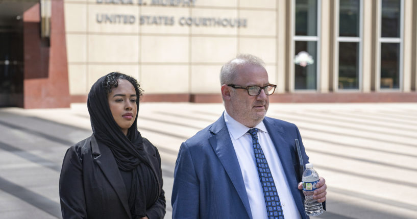 Ladan Mohamed Ali, left, a Seattle woman who attempted to bribe a Minnesota juror with a bag of $120,000 in cash in exchange for an acquittal in one of the country's largest COVID-19-related fraud cases, and her attorney, Eric Newmark, leave the Diana E. Murphy U.S. Courthouse on Thursday in Minneapolis, following after a hearing where she plead guilty.