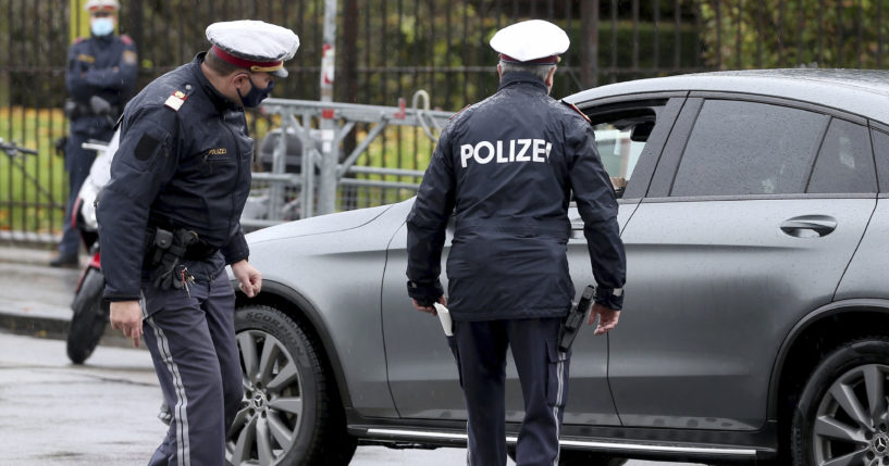 Police officers check a car in downtown Vienna, Austria, on Oct. 30, 2020.