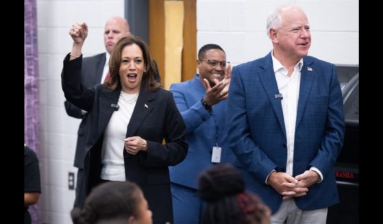 Democratic presidential candidate US Vice President Kamala Harris and her running mate, Governor Tim Walz,enjoy music by members of the marching band at Liberty County High School in Hinesville, Georgia, August 28, 2024, as they travel across Georgia for a 2-day campaign bus tour.