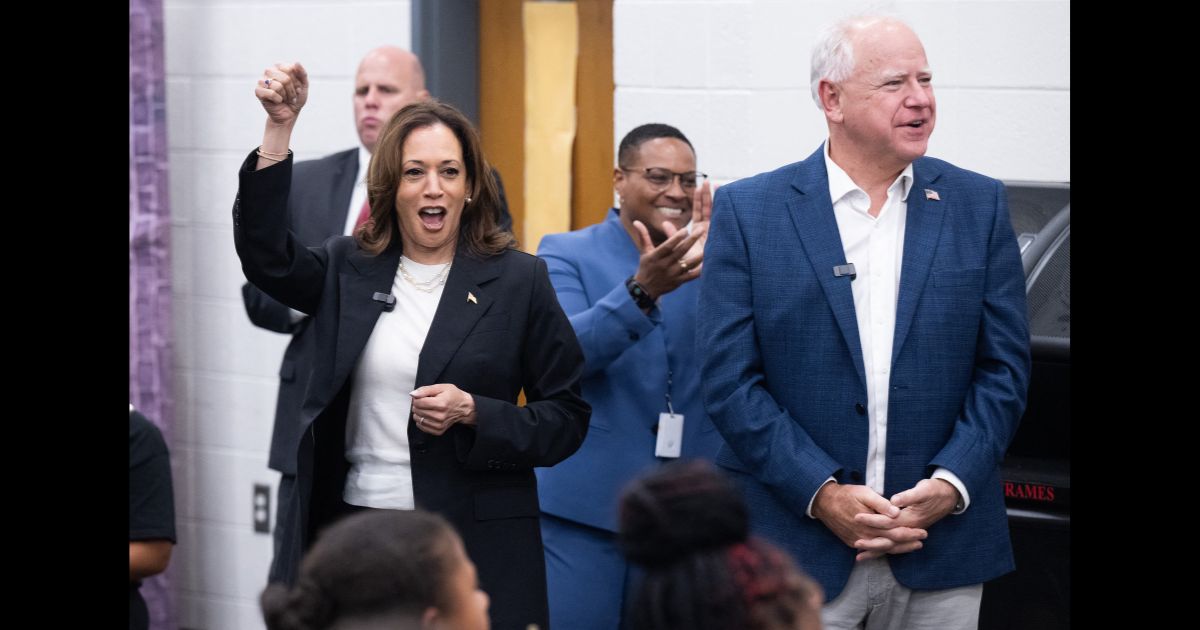 Democratic presidential candidate US Vice President Kamala Harris and her running mate, Governor Tim Walz,enjoy music by members of the marching band at Liberty County High School in Hinesville, Georgia, August 28, 2024, as they travel across Georgia for a 2-day campaign bus tour.