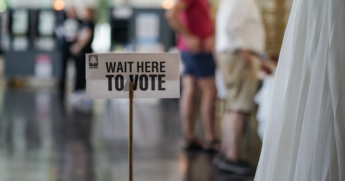 A 'Wait Here To Vote' sign is seen in a polling location as voters check in to cast ballots on May 21, 2024 in Atlanta, Georgia.