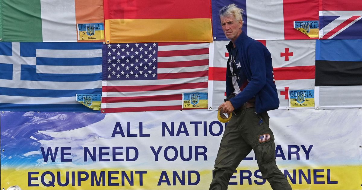 This photograph taken on Independence Square in Kyiv on June 23, 2022 shows US citizen Ryan Wesley Routh sticking up national flags of the countries helping Ukraine.