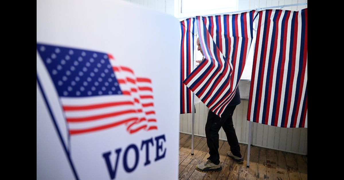 A voter prepares to leave a voting booth as they take part in the New Hampshire primary at Sanbornton Old Town Hall on Tuesday January 23, 2024 in Sanbornton, NH.