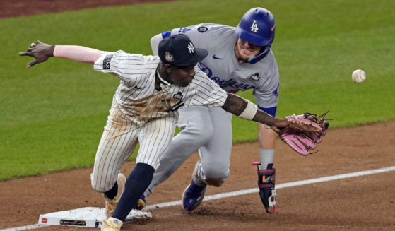 Los Angeles Dodgers' Kiké Hernández, right, is safe at third as New York Yankees third baseman Jazz Chisholm Jr. reaches for a throw from shortstop Anthony Volpe during the fifth inning in Game 5 of the baseball World Series, Wednesday, Oct. 30, 2024, in New York. Volpe was charged with a throwing error.