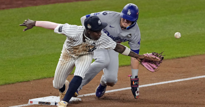 Los Angeles Dodgers' Kiké Hernández, right, is safe at third as New York Yankees third baseman Jazz Chisholm Jr. reaches for a throw from shortstop Anthony Volpe during the fifth inning in Game 5 of the baseball World Series, Wednesday, Oct. 30, 2024, in New York. Volpe was charged with a throwing error.