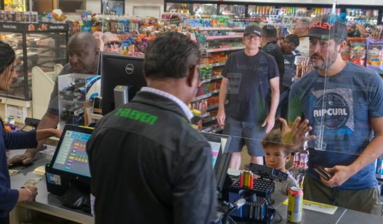 Customers wait in line to purchase items at a 7-Eleven convenience store in Chino Hills, California, on July 28, 2022.