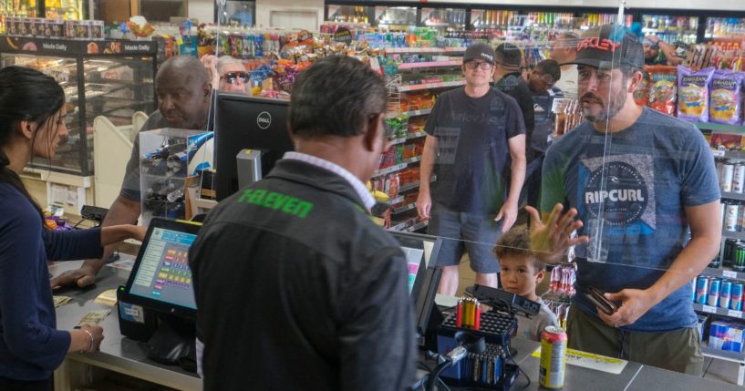 Customers wait in line to purchase items at a 7-Eleven convenience store in Chino Hills, California, on July 28, 2022.