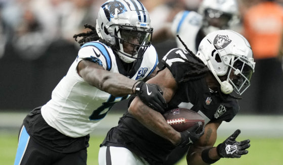 Las Vegas Raiders wide receiver Davante Adams is tackled by Carolina Panthers cornerback Jaycee Horn during the first half of an NFL football game in Las Vegas on Sept. 22.