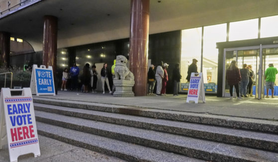 People line up outside the Frank P. Zeidler Municipal Building during the first day of Wisconsin's in-person absentee voting in Milwaukee on Tuesday.