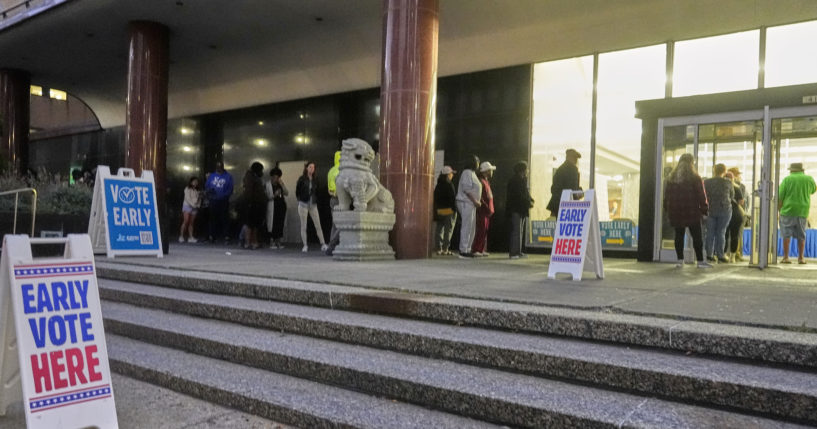 People line up outside the Frank P. Zeidler Municipal Building during the first day of Wisconsin's in-person absentee voting in Milwaukee on Tuesday.