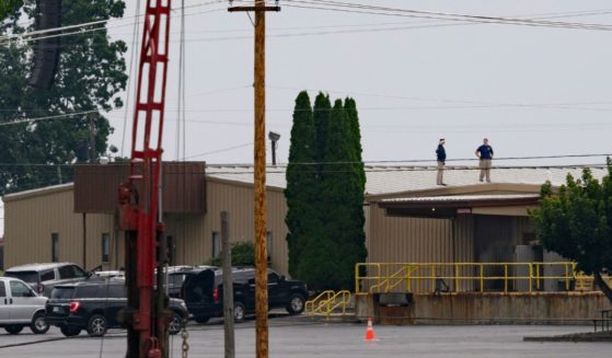 On July 14, two FBI investigators scan the roof of AGR International Inc, the building adjacent to the Butler Fairgrounds, from which alleged shooter Matthew Thomas Crooks fired at former President Donald J. Trump at a campaign rally in Butler, Pennsylvania, on July 13.