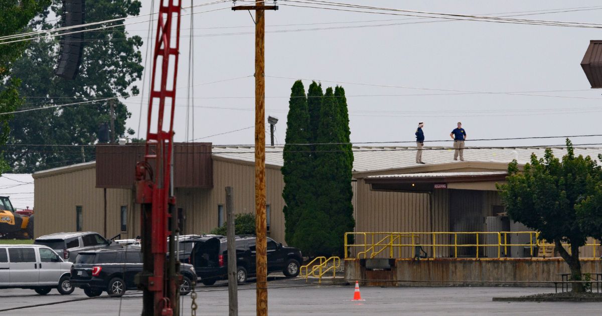 On July 14, two FBI investigators scan the roof of AGR International Inc, the building adjacent to the Butler Fairgrounds, from which alleged shooter Matthew Thomas Crooks fired at former President Donald J. Trump at a campaign rally in Butler, Pennsylvania, on July 13.