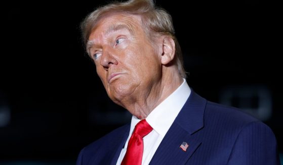 Former President Donald Trump listens as former Rep. Tulsi Gabbard speaks at a campaign rally in Greensboro, North Carolina, on Tuesday.