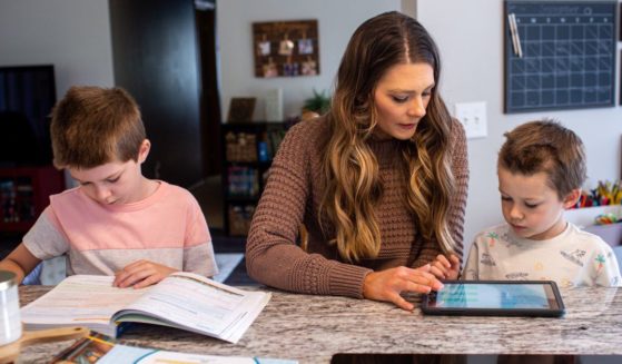 Ashley Perisian, center, leads her sons Hendrix Perisian, 7, and Gibson Perisian, 9, in a morning lesson during a homeschooling session in Buffalo, Minnesota, on Sept. 19, 2023.