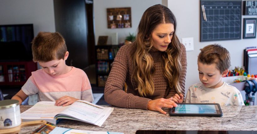 Ashley Perisian, center, leads her sons Hendrix Perisian, 7, and Gibson Perisian, 9, in a morning lesson during a homeschooling session in Buffalo, Minnesota, on Sept. 19, 2023.