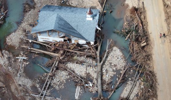 An aerial view shows people walking past a destroyed church in the aftermath of Hurricane Helene flooding in Swannanoa, North Carolina, on Sunday.