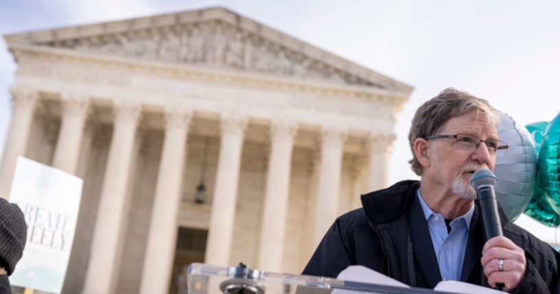 Colorado baker Jack Phillips, seen speaking to supporters outside the Supreme Court in Washington in December of 2022, said his 12 years of court cases brought by gay and transgender activists have strengthened his faith.