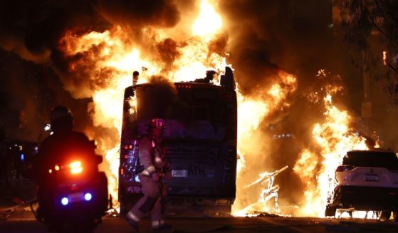 A firefighter and police officer work near a Metro bus burning following Dodger fan celebrations in the area which turned unruly, after the Los Angeles Dodgers defeated the New York Yankees in Game 5 to win the World Series in Los Angeles on Wednesday.