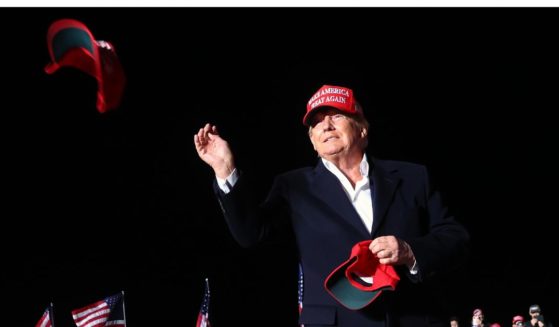 Former President Donald Trump tosses a MAGA hat to the crowd before speaking at a rally in Florence, Arizona, on Jan. 15, 2022.