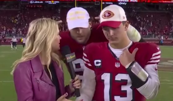 As San Fransico 49ers quarterback Brock Purdy, center, was being interviewed after the game against the Dallas Cowboys on Sunday, 49ers defensive lineman Nick Bosa, right, crashed the interview wearing a MAGA hat.