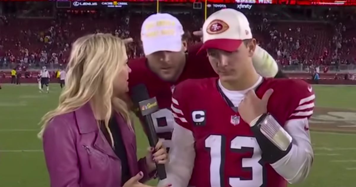 As San Fransico 49ers quarterback Brock Purdy, center, was being interviewed after the game against the Dallas Cowboys on Sunday, 49ers defensive lineman Nick Bosa, right, crashed the interview wearing a MAGA hat.