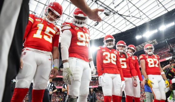 Patrick Mahomes #15, Chris Jones #95, L'Jarius Sneed #38, Tommy Townsend #5, Harrison Butker #7, and Travis Kelce #87 of the Kansas City Chiefs look on as referee Bill Vinovich (52) performs the coin toss prior to Super Bowl LVIII.