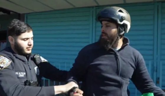 The bicycle-riding protester shouted "Free Palestine" and attempted to burn what appeared to be an Israeli Defense Forces flag until he was detained by police.