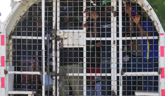 Undocumented Haitians detained by immigration officials stand inside a police vehicle, in Dajabon, Dominican Republic, in a file photo from May 17.