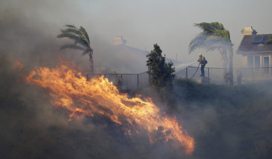 A firefighter sprays water in front of an advancing wildfire in Porter Ranch, California, on Oct. 11, 2019.