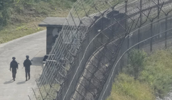 Korean guards near a security fence.