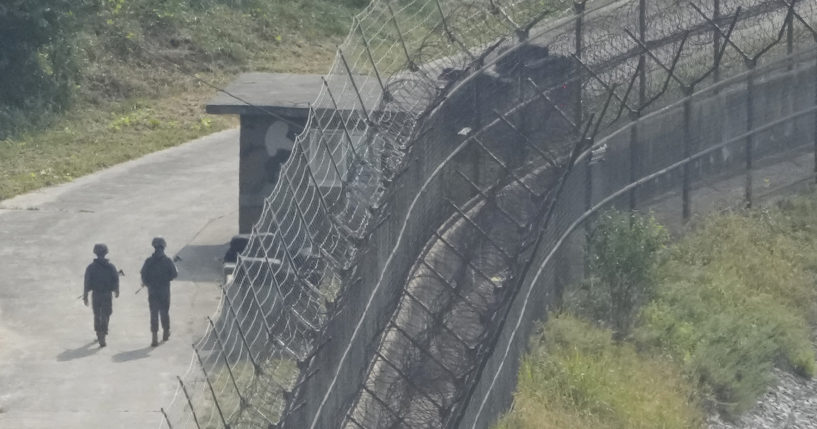 Korean guards near a security fence.