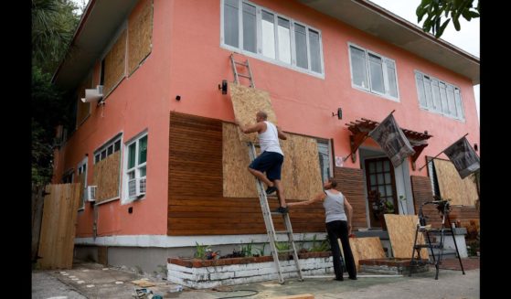 Edward Montgomery and Courtney Viezux board up Montgomery's apartment building as they prepare for the possible arrival of Hurricane Ian on September 27, 2022 in St Petersburg, Florida.