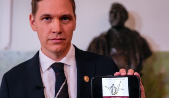 Jørgen Watne Frydnes, chairman of the Norwegian Nobel Committee, holds a cell phone displaying the logo of Japanese organization Nihon Hidankyp, winner of the 2024 Nobel Peace Prize, during a news conference at The Norwegian Nobel Institute in Oslo, Norway on October Friday. (Javad Parsa / NTB / AFP via Getty Images)