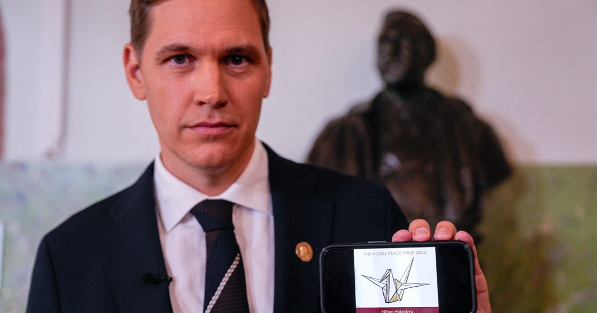 Jørgen Watne Frydnes, chairman of the Norwegian Nobel Committee, holds a cell phone displaying the logo of Japanese organization Nihon Hidankyp, winner of the 2024 Nobel Peace Prize, during a news conference at The Norwegian Nobel Institute in Oslo, Norway on October Friday. (Javad Parsa / NTB / AFP via Getty Images)