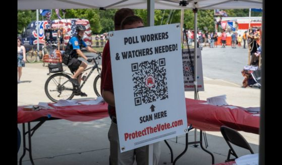 A booth for registering poll workers stands near to where people line up to see Republican presidential nominee, former U.S. President Donald Trump speak on July 31, 2024 in Harrisburg, Pennsylvania.