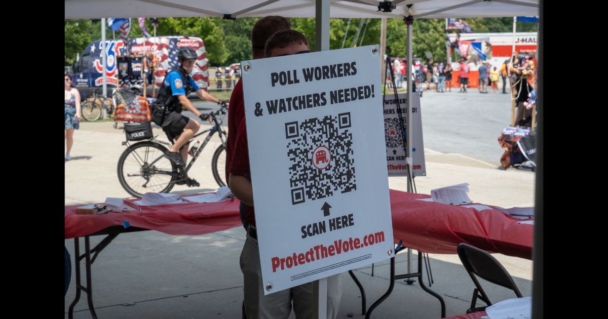 A booth for registering poll workers stands near to where people line up to see Republican presidential nominee, former U.S. President Donald Trump speak on July 31, 2024 in Harrisburg, Pennsylvania.