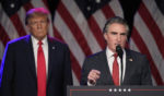 Former President Donald Trump listens as North Dakota Gov. Doug Burgum speaks at a caucus night rally in Las Vegas in a file photo dated Feb. 8.