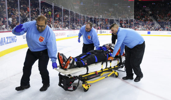 Referee Mitch Dunning, center, is stretchered off the ice after an injury during the first period of an NHL hockey game between the Philadelphia Flyers and the Colorado Avalanche, Monday, Nov. 18, 2024, in Philadelphia.