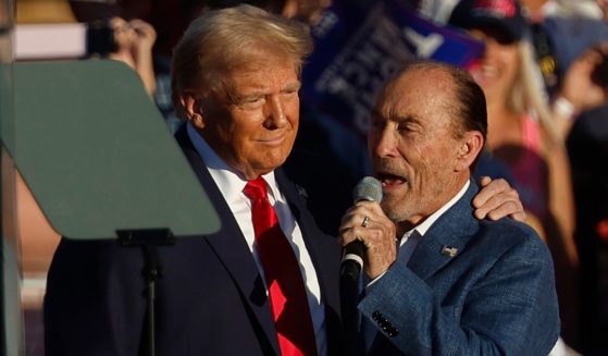 Lee Greenwood, right, sings as former President Donald Trump, left, takes the stage during a campaign rally at the Butler Farm Show grounds in Butler, Pennsylvania, on Oct. 5.