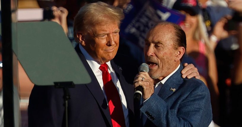 Lee Greenwood, right, sings as former President Donald Trump, left, takes the stage during a campaign rally at the Butler Farm Show grounds in Butler, Pennsylvania, on Oct. 5.