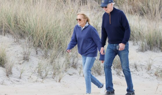 President Joe Biden, right, and first lady Jill Biden, left, walk on the beach at Gordons Pond in Rehoboth Beach, Delaware, on Sunday.