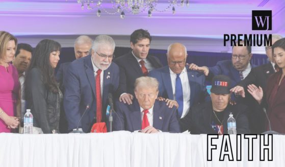 A group of people pray with former President Donald Trump during a roundtable discussion at the Latino Summit in Doral, Florida, on Oct. 22, two weeks before Trump was re-elected to the presidency.