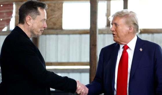 Elon Musk, left, shakes hands with former President Donald Trump, right, back stage during a campaign rally in Butler, Pennsylvania, on Oct. 5.