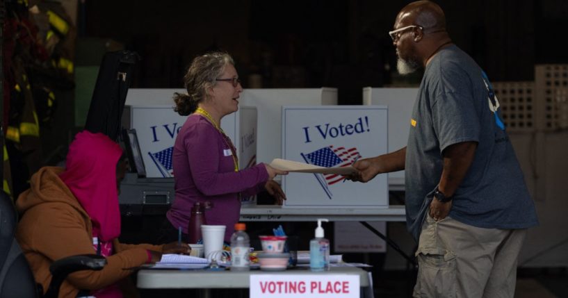 An election worker hands a ballot to a voter at a polling location inside the Pittsburgh Bureau of Fire Engine Company #15 house in Pittsburgh, Pennsylvania, on Tuesday.