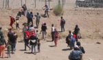 Illegal immigrants seeking to enter the United States attempt to cut a barbed wire fence installed by the Texas National Guard at the border with Ciudad Juarez, Mexico, on May 13.