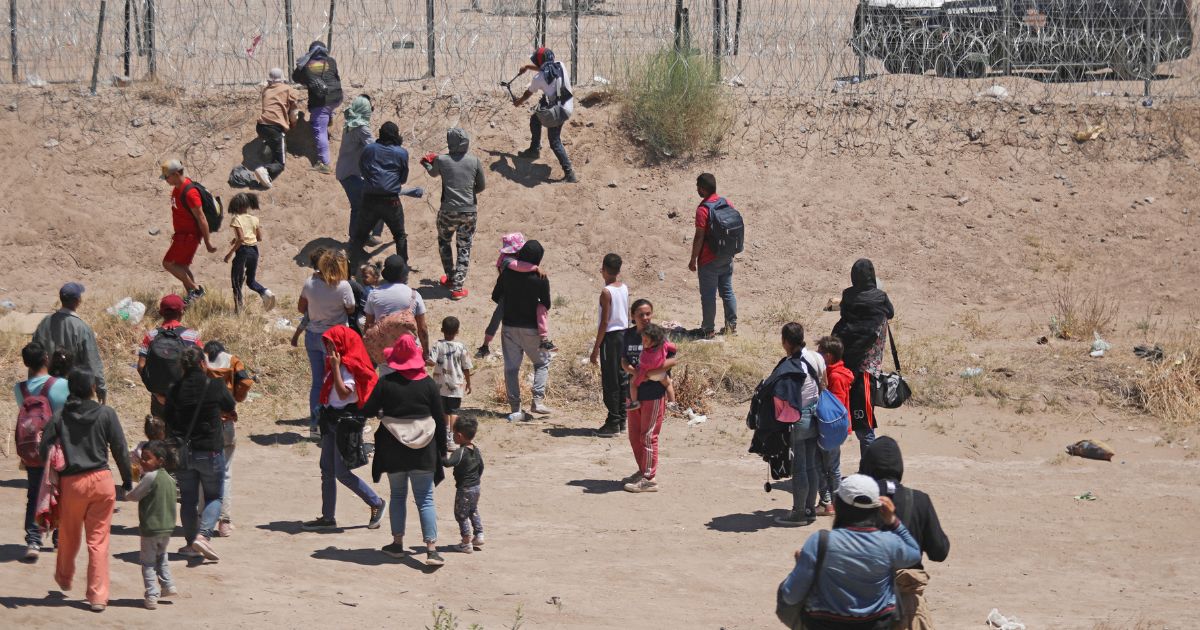 Illegal immigrants seeking to enter the United States attempt to cut a barbed wire fence installed by the Texas National Guard at the border with Ciudad Juarez, Mexico, on May 13.